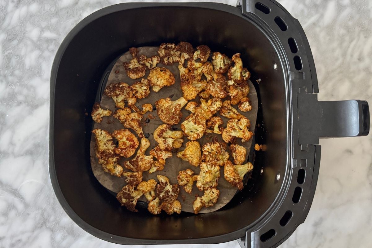 Air fried cauliflower florets in air fryer basket