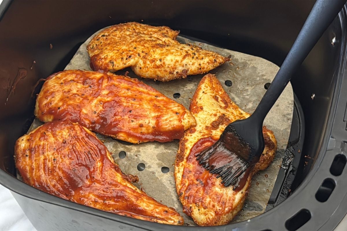 BBQ sauce brushed onto cooked chicken in the air fryer