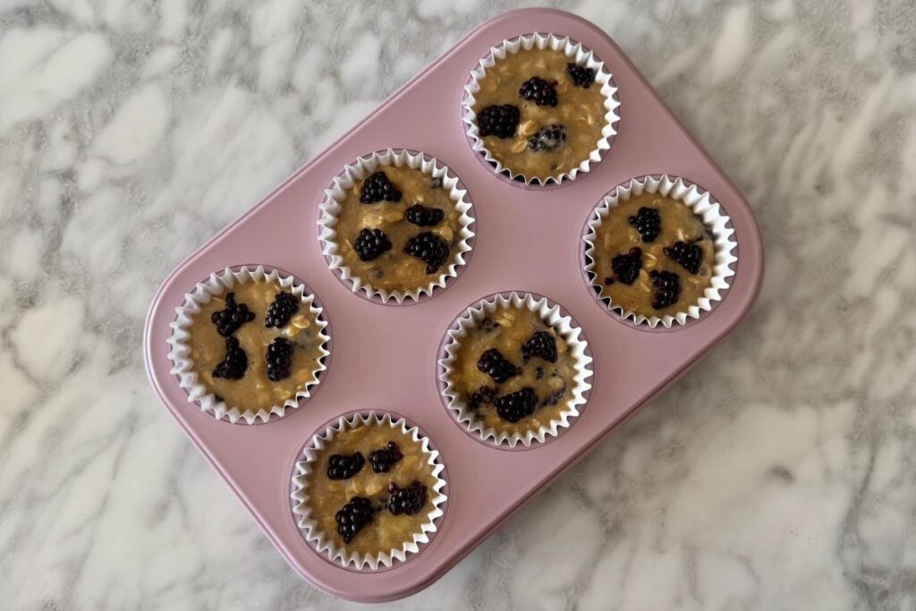 Banana blackberry muffins in a muffin pan