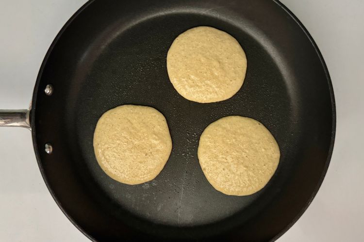 Banana cottage cheese pancakes cooking on skillet