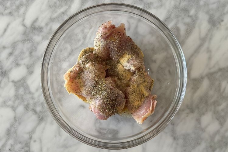 Boneless skinless chicken thighs in large bowl