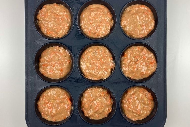 Carrot cake batter in a muffin pan
