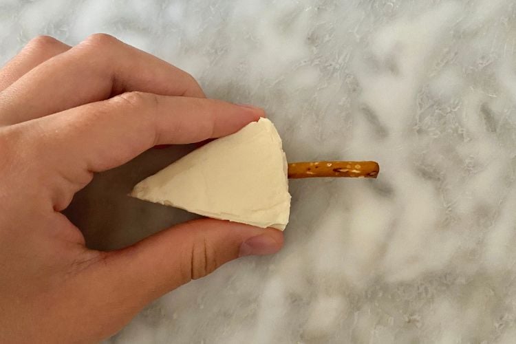 Cheese wedge with pretzel stick