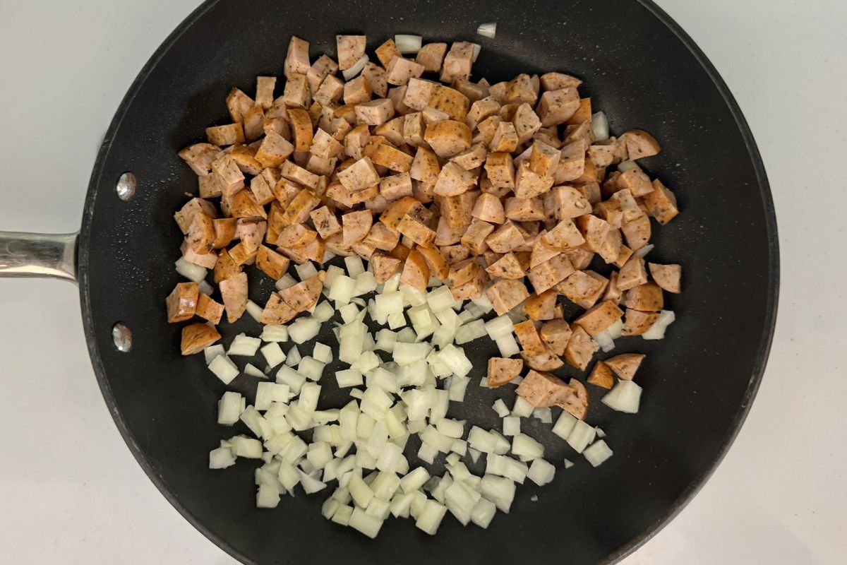 Chopped sausage and diced onion in a pan