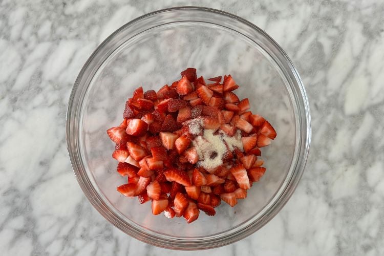 Chopped strawberries in bowl with lemon and sugar