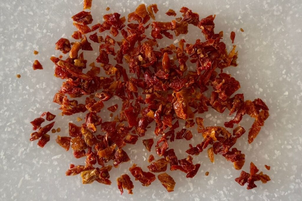 Chopped sun-dried tomatoes on cutting board