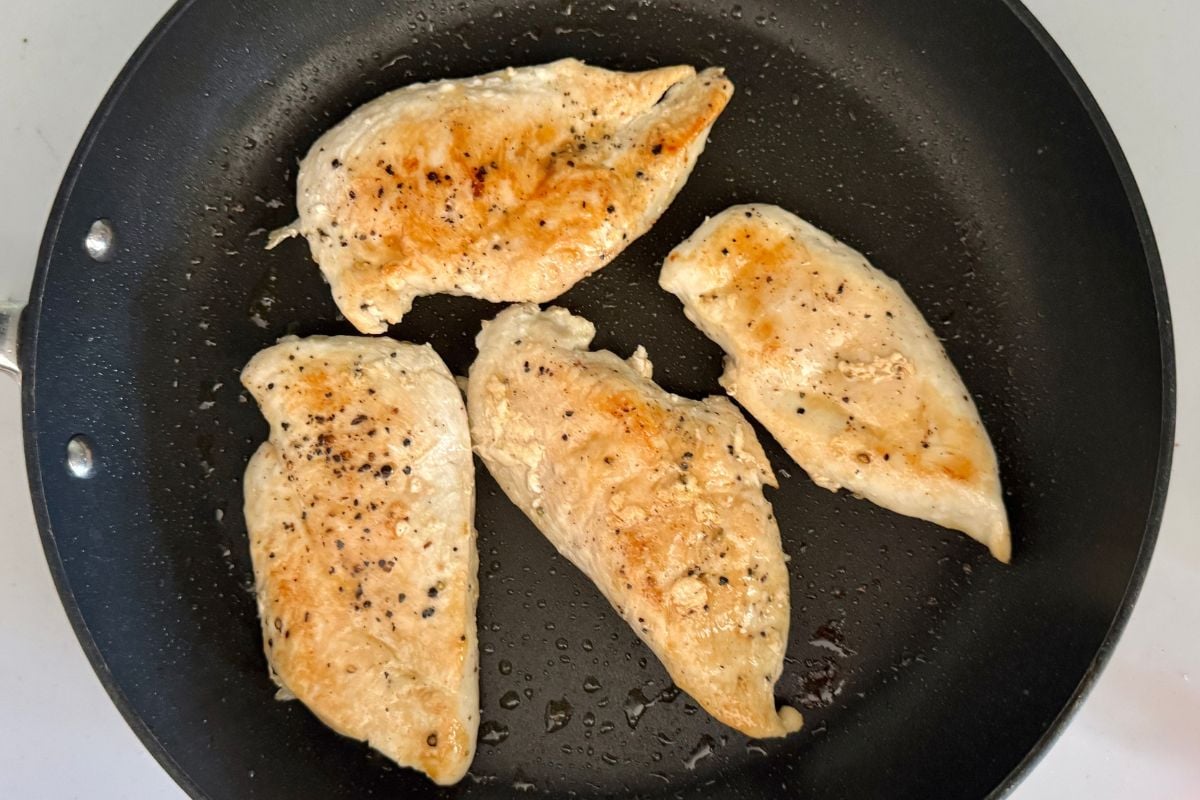Cooked chicken cutlets in skillet for Marry Me Chicken