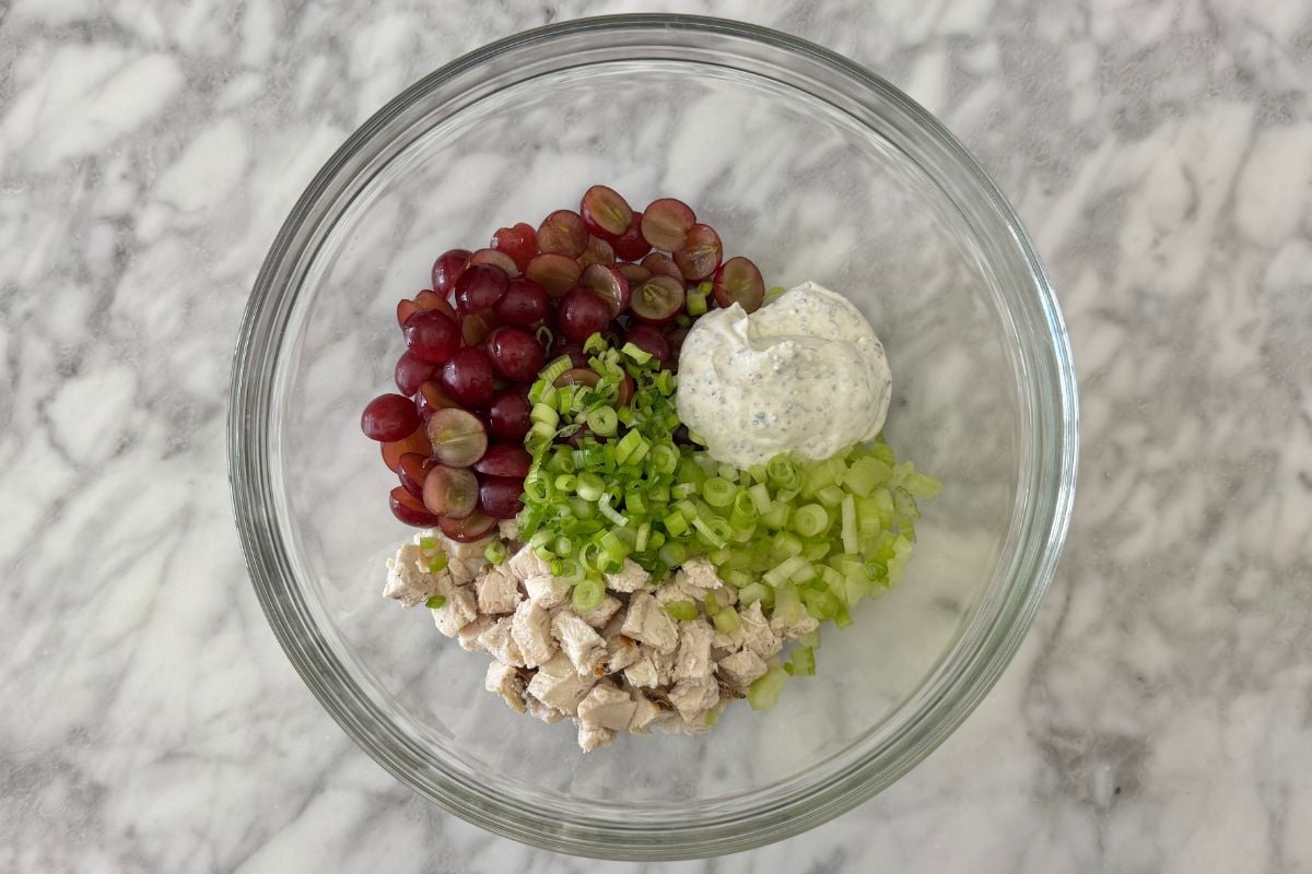 Cooked chicken in bowl with grapes and tarragon