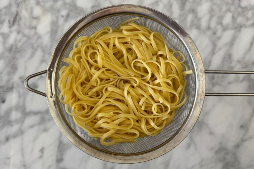 Cooked linguine pasta in a strainer