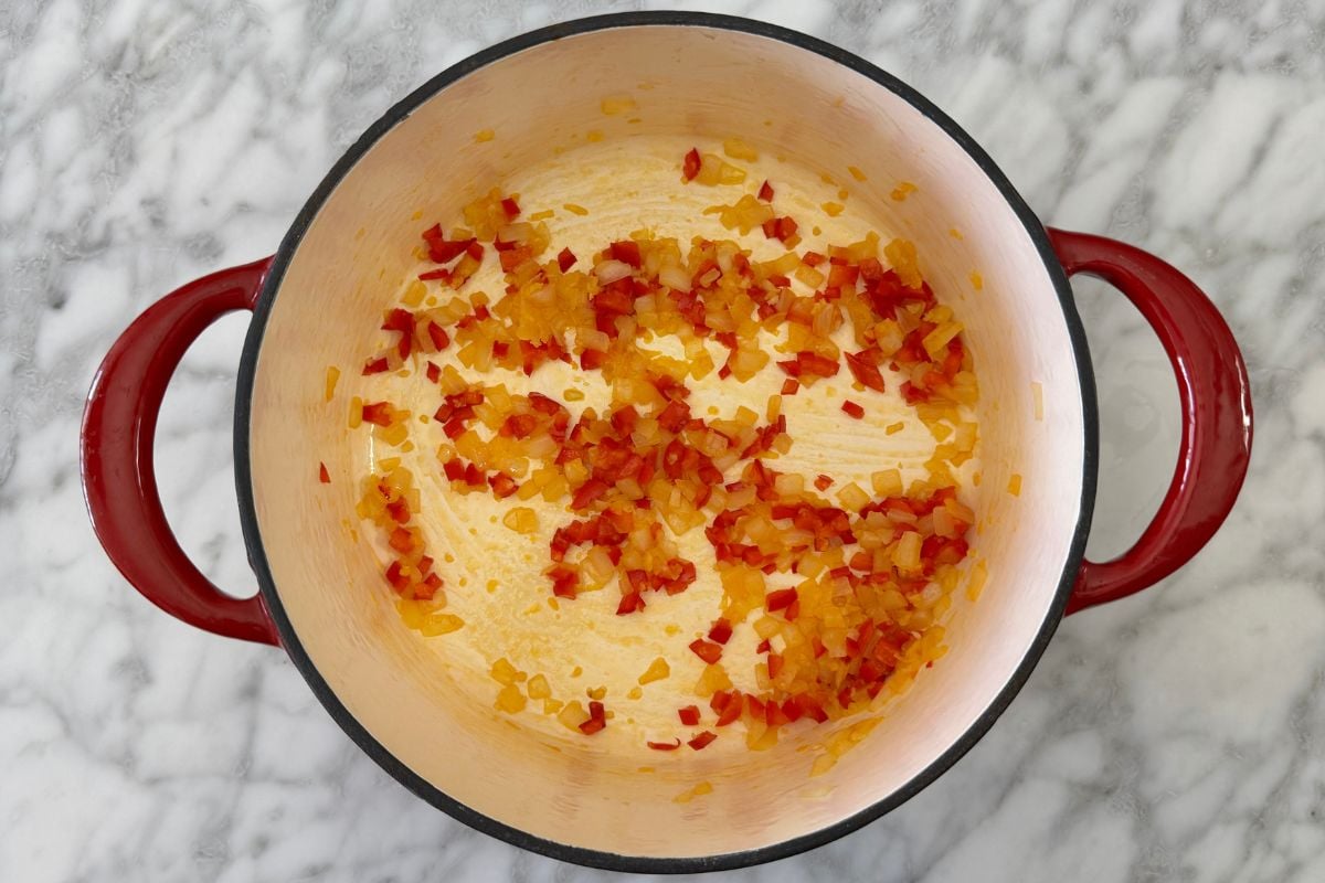 Cooked onion and red bell pepper in Dutch oven