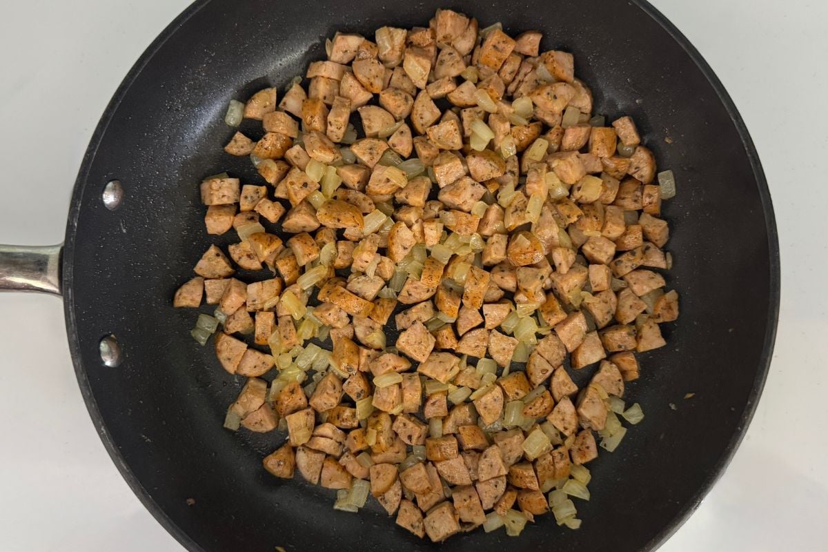 Cooked sausage and onions in a pan