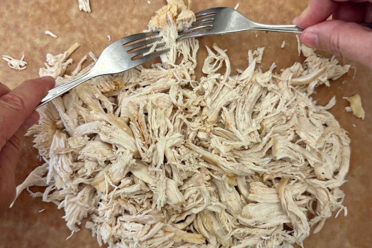 Cooked shredded chicken on a cutting board