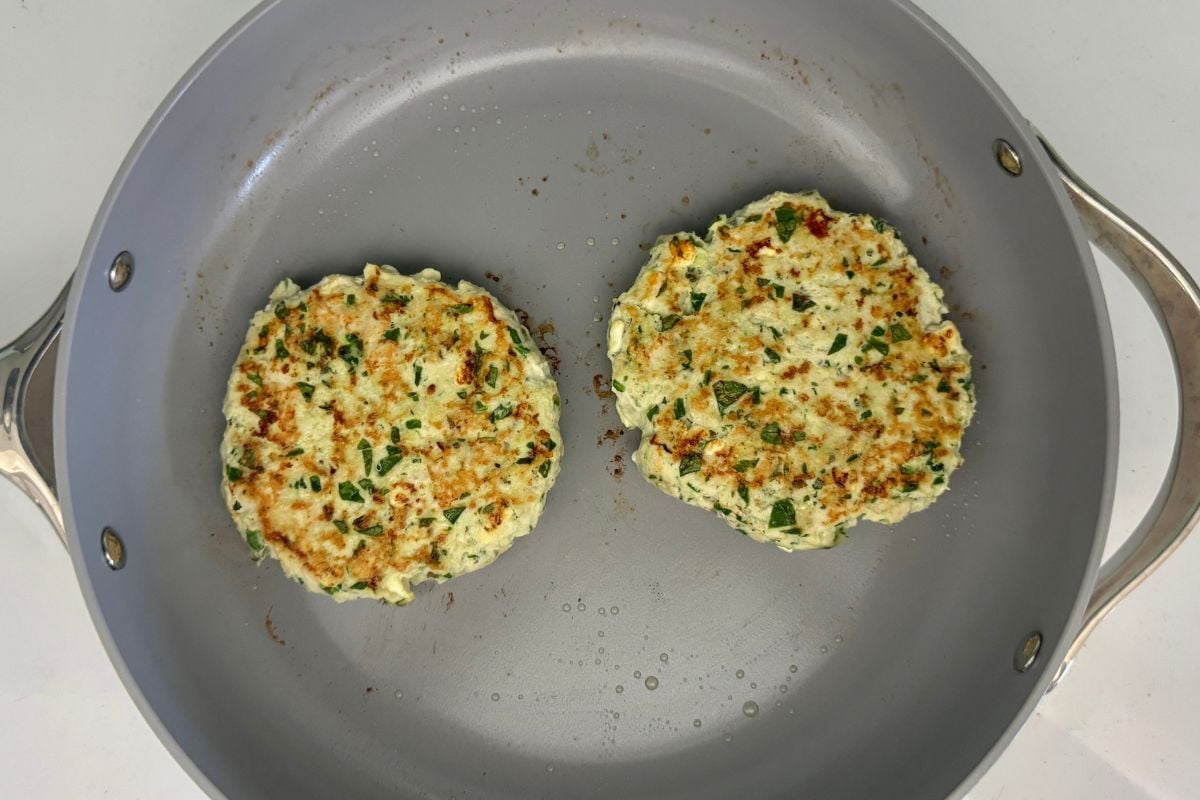 Cooked spinach and feta turkey burgers in pan