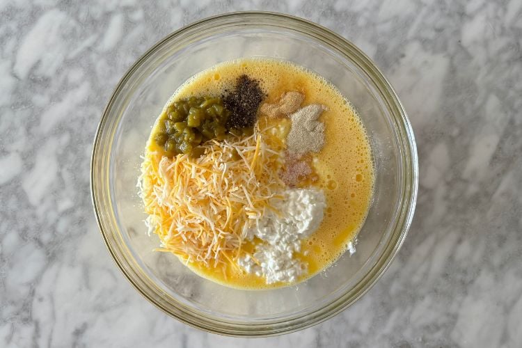 Cottage cheese and green chiles in bowl with eggs