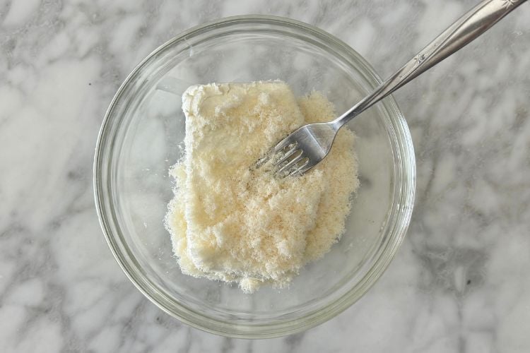 Cream cheese in bowl with truffle oil and Parmesan