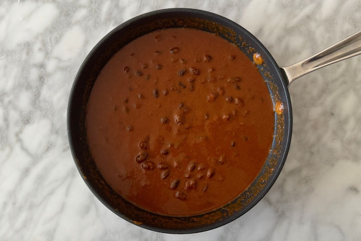 Enchilada sauce and black beans in skillet