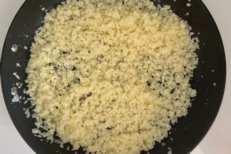 Frozen riced cauliflower in a skillet