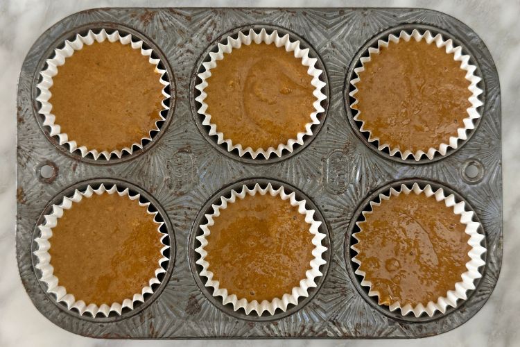 Gingerbread muffin batter in muffin pan