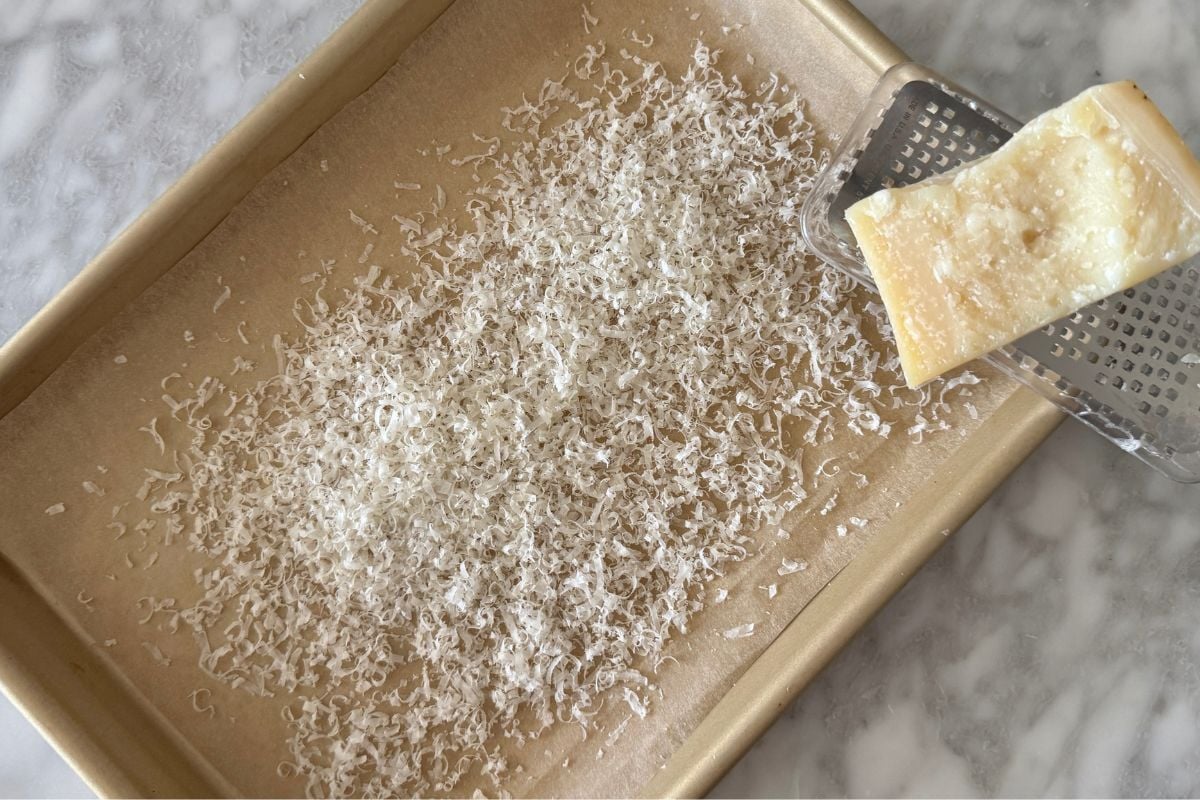 Grated parmesan on a sheet pan lined with parchment paper