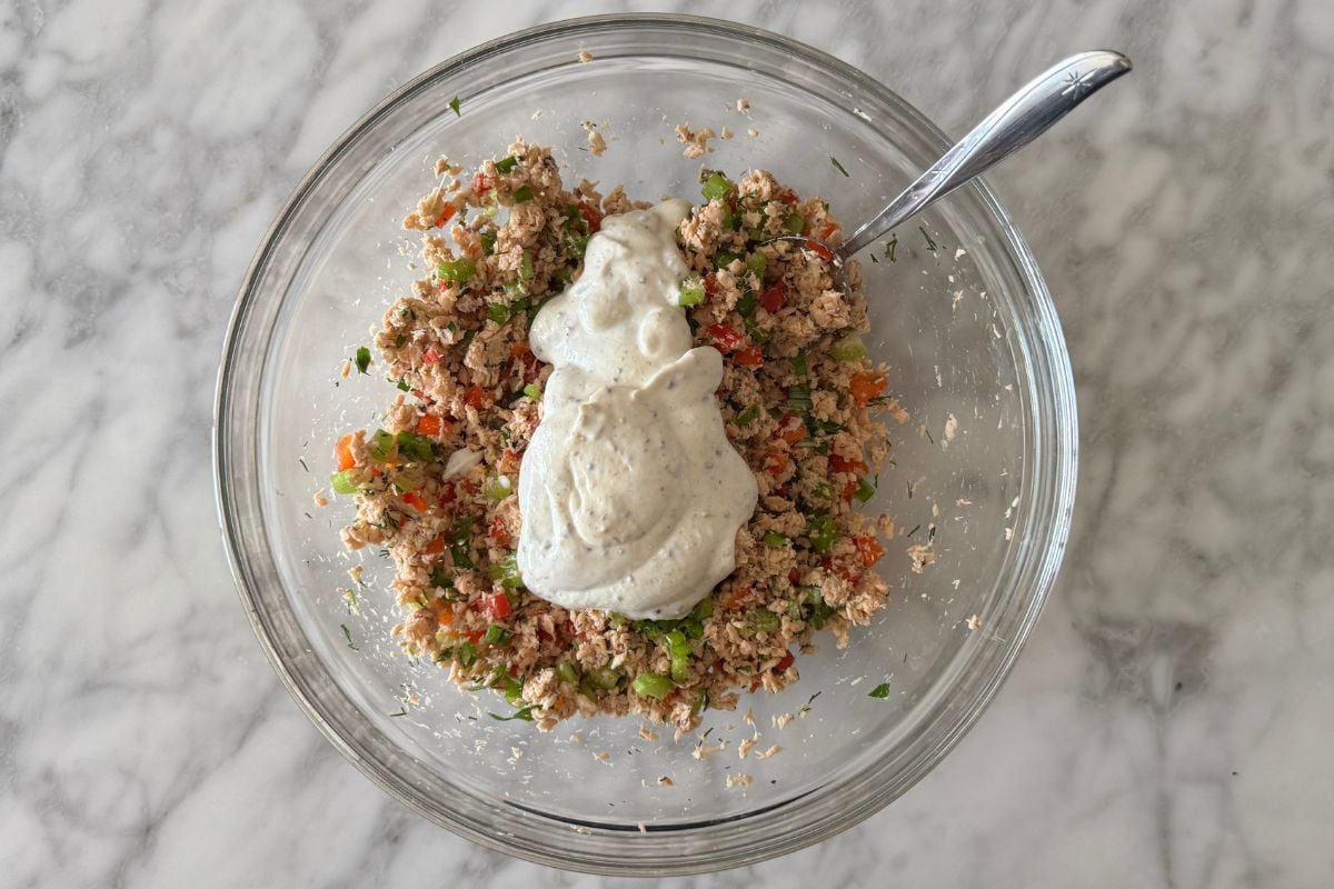 Greek yogurt dressing in bowl with salmon mixture