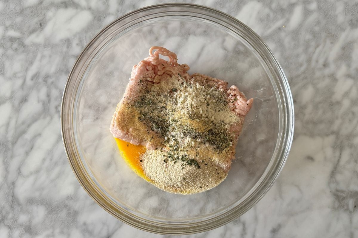 Ground chicken in bowl with seasonings