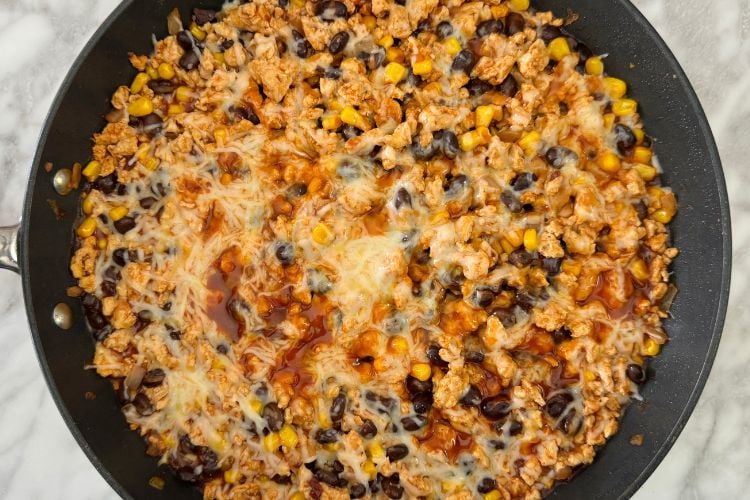 Ground turkey enchilada skillet topped with melted cheese