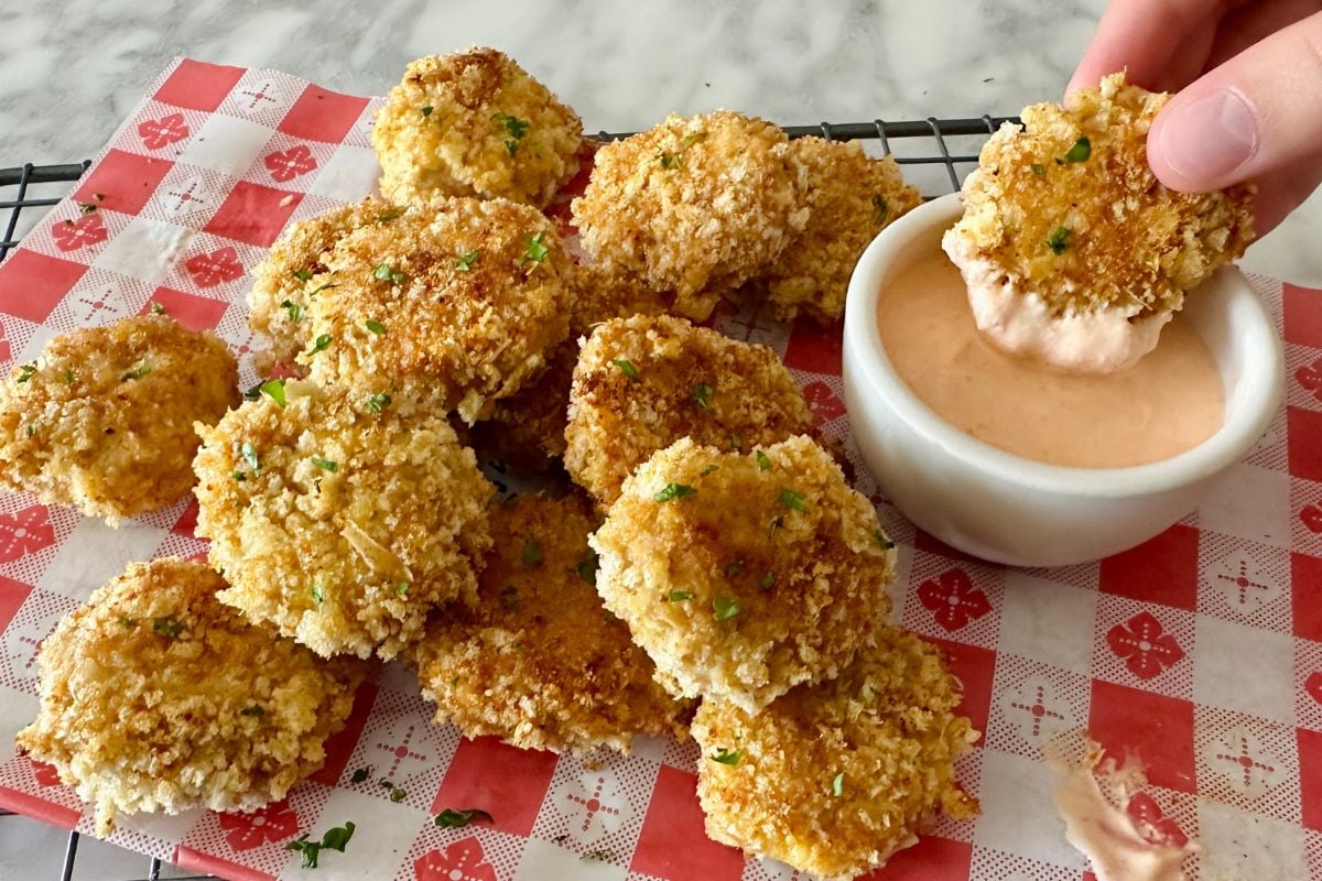 Homemade chicken nuggets dipped in sauce in a bowl