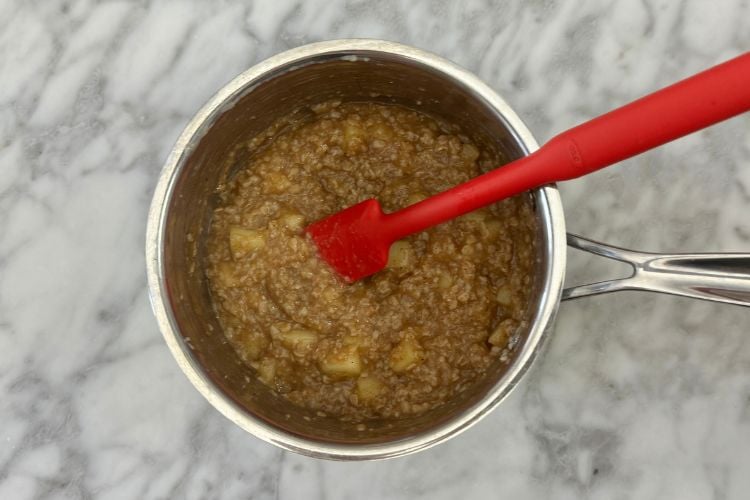 Mixed apple cinnamon oatmeal in saucepan