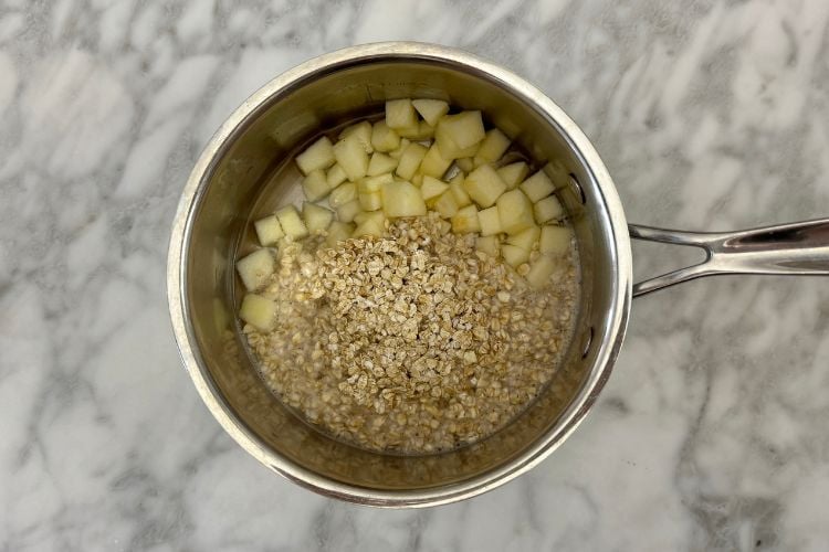 Oats and chopped apples in saucepan