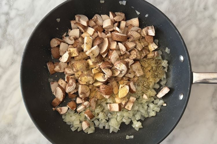 Onions mushrooms and seasonings in pan