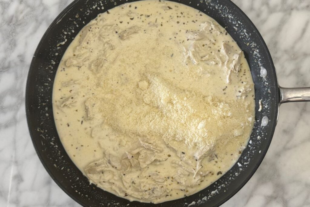 Grated Parmesan cheese in Alfredo sauce