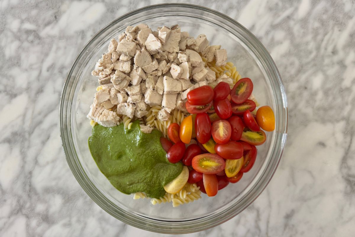 Pasta pesto and cooked chicken in bowl for pasta salad