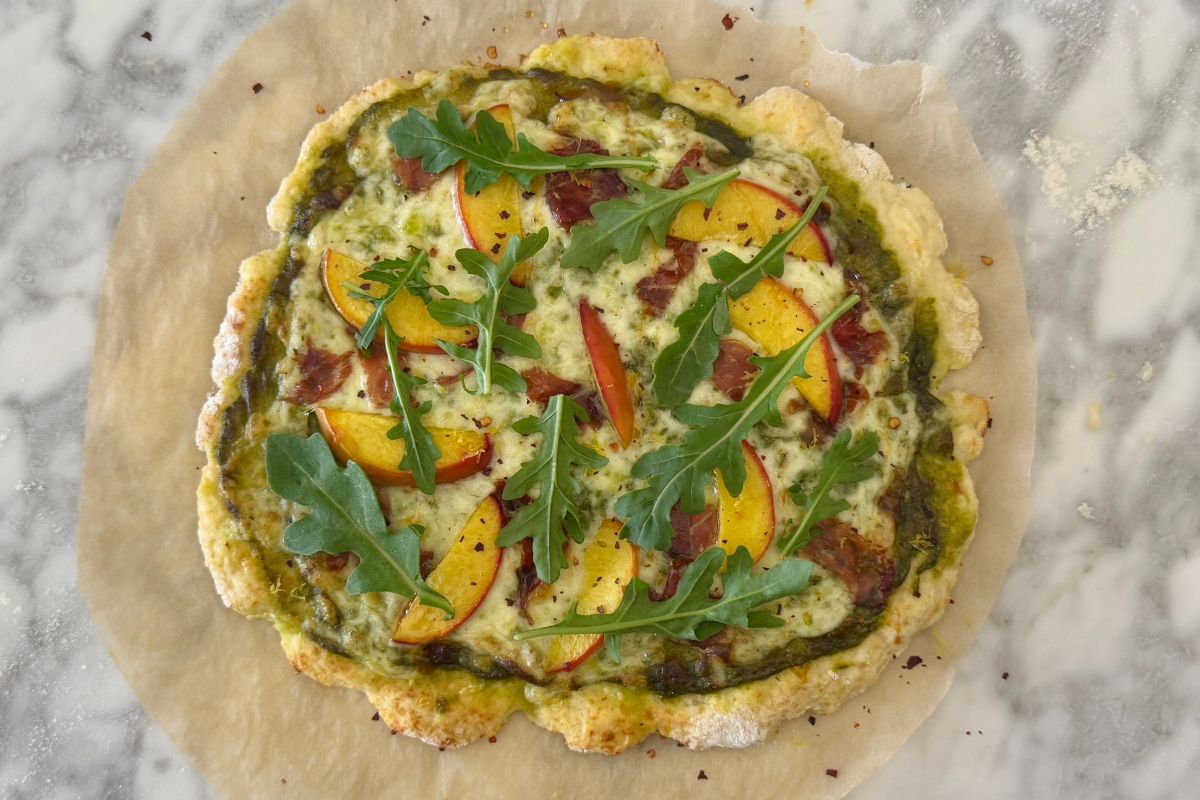 Pesto pizza with peaches and prosciutto