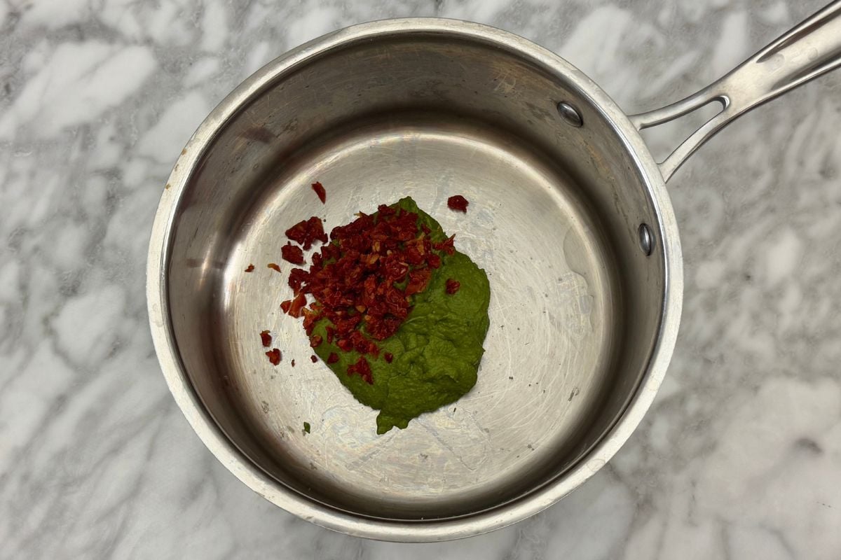 Pistachio pesto and sun-dried tomatoes in saucepan