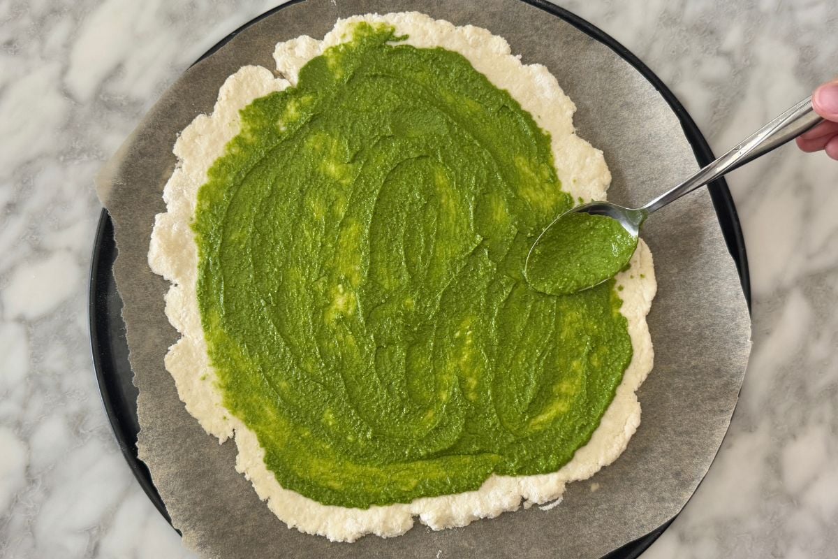 Pizza dough with pesto sauce