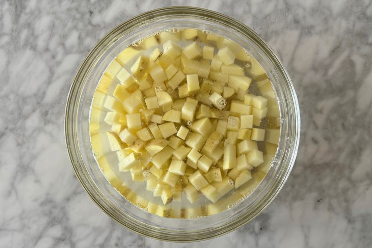 Potatoes in bowl of cold water
