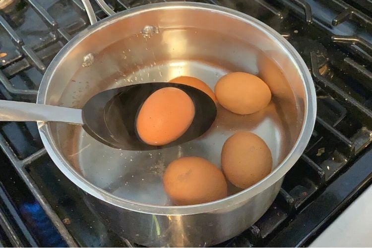 Putting egg into boiling water