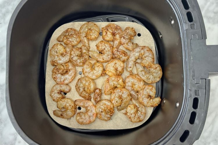 Seasoned shrimp in air fryer basket
