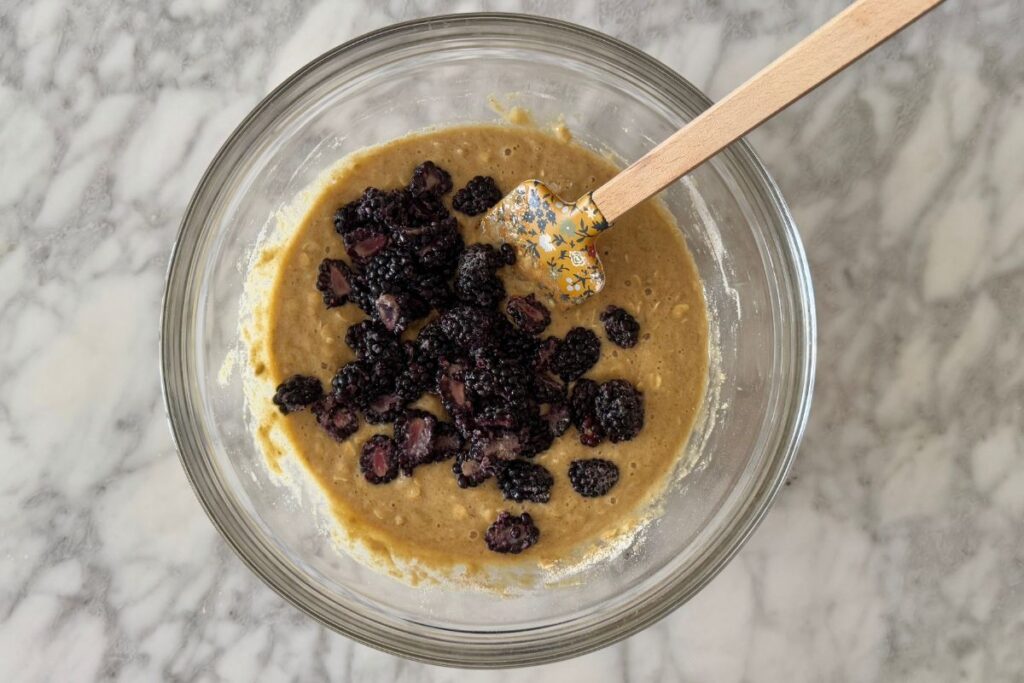 Sliced blackberries in muffin batter