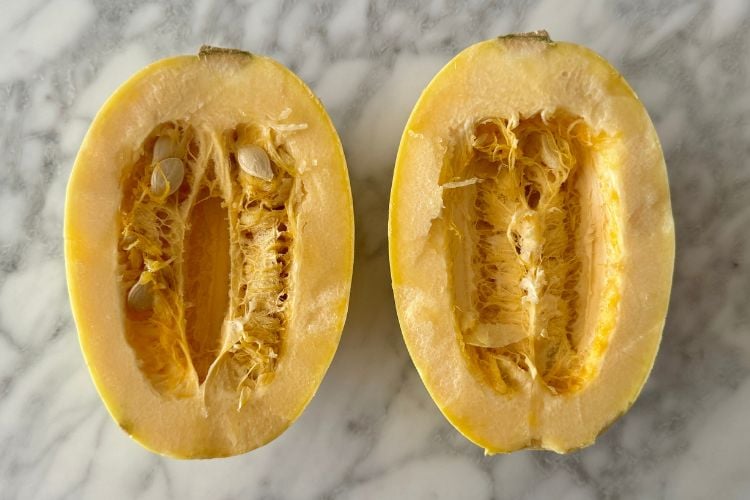 Small spaghetti squash cut in half with seeds