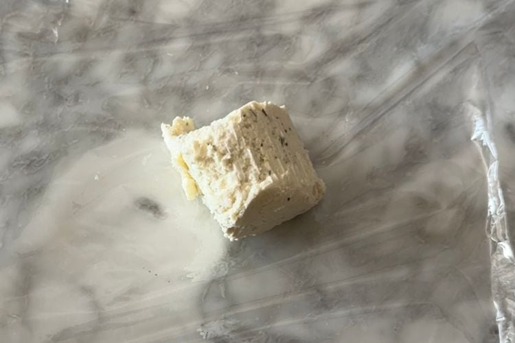 Smaller piece of cheese on plastic wrap
