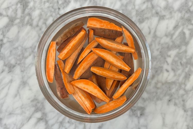 Sweet potato wedges soaking in bowl