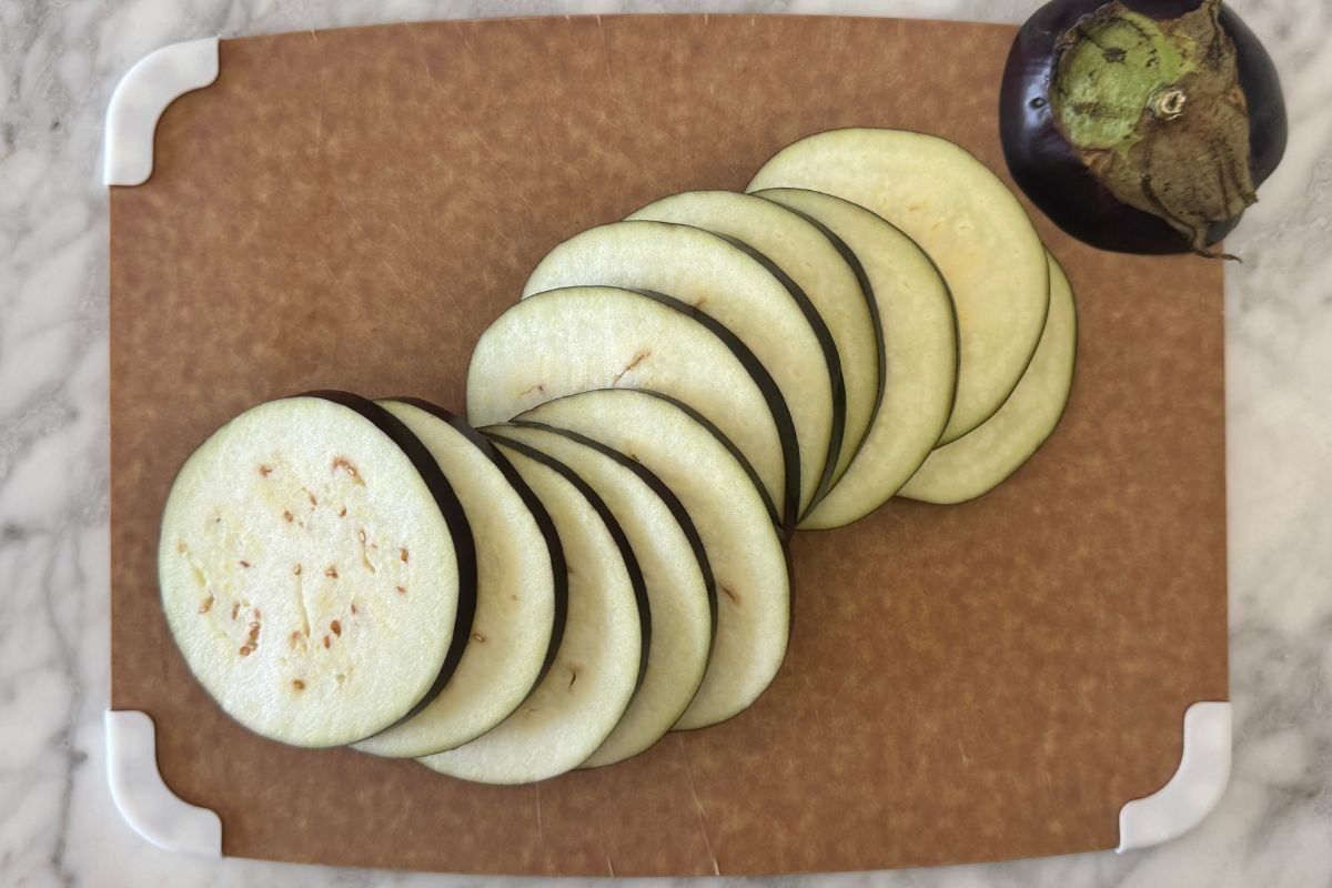 Thinly sliced eggplant on cutting board