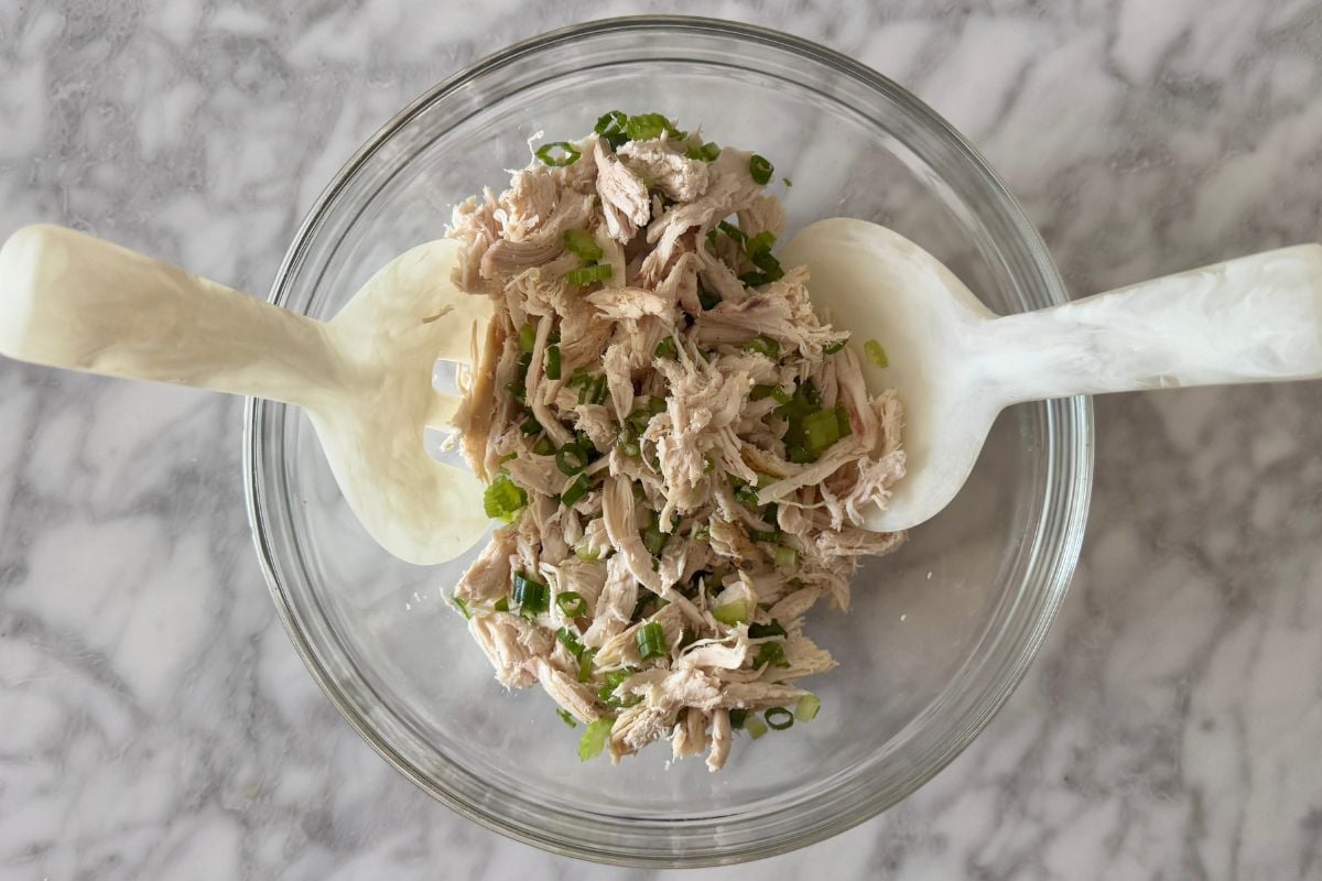 Tossed cooked rotisserie chicken in bowl