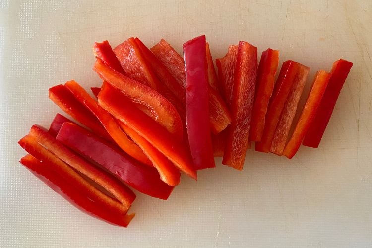 chopped red bell pepper on board