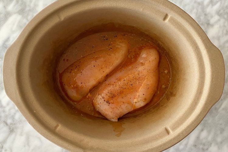ingredients and chicken in slow cooker